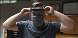  ?? The Sentinel-Record/Grace Brown ?? HELPING OUT: Garland County Library Director Adam Webb models a face shield Tuesday produced by one of the library’s 3D printers. The protective equipment will go to local health care workers and first responders.