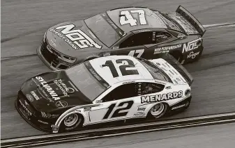  ?? Chris Graythen / Getty Images ?? Ryan Blaney, driver of the No. 12 Menards/Sylvania Ford, edges past Ricky Stenhouse Jr., driver of the No. 47 NOS Energy Drink Chevrolet. Stenhouse finished second behind Blaney.