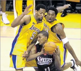  ?? Jeff Gross Getty Images ?? ROBERT HORRY and Kobe Bryant defend Philadelph­ia’s Raja Bell in Game 1 of the 2001 Finals at Staples Center. The Lakers won the title, the second of three that Horry and Bryant won together.