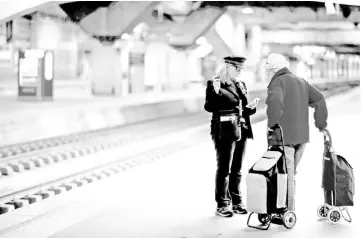  ?? — Reuters photo ?? An agent talks with a woman walking on the platform at Montparnas­se railway station during a nationwide strike by French SNCF railway workers in Paris in this file photo.