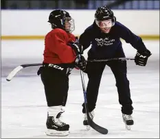  ?? ?? Quinnipiac University medical school student Jake Baekey, right, assists children in the co-ed Hockey Haven program with basic skating skills at the Ralph Walker Rink in New Haven.