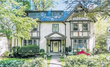  ??  ?? This Tudor-style home is at 104 Oakdale Road in Roland Park and is surrounded by lush greenery.