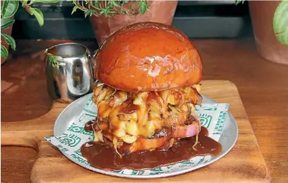  ??  ?? The burger contains onion, beef pattie, hand cut potato fries, and four different types of cheese all covered in gravy.