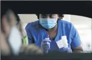  ?? WILFREDO LEE — THE ASSOCIATED PRESS ?? Health care worker Rahaana Smith instructs passengers how to use a nasal swab at a drive-thru COVID-19 testing site July 24 in Miami.