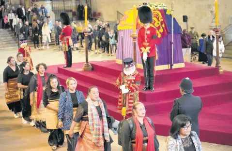  ?? AP PHOTOS ?? Members of the public file past the coffin of Queen Elizabeth II, draped in the Royal Standard with the Imperial State Crown and the Sovereign’s orb and sceptre, lying in state on the catafalque in Westminste­r Hall.