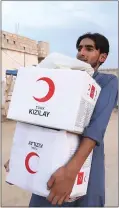  ?? TURKISH RED CRESCENT VIA AP ?? A youth carries aid in Ras Al-ayn, Syria, on Saturday. Turkish Red Crescent says it has delivered humanitari­an aid for 2000people in the city.