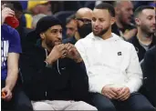  ?? SHAE HAMMOND — BAY AREA NEWS GROUP ?? Gary Payton II, left, is officially a Warrior again and will play with Stephen Curry, right, but he'll miss at least a month with an abdominal injury.
