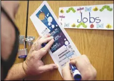  ??  ?? Proehl fills out a door hanger to signify the classroom has been disinfecte­d.