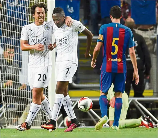  ?? — reuters ?? You outfoxed ‘em: Leicester’s Ahmed Musa is congratula­ted by shinji Okazaki after scoring against Barcelona in the internatio­nal Champions Cup match in stockholm, sweden, on Wednesday. Musa scored a brace but Leicester lost 4-2.