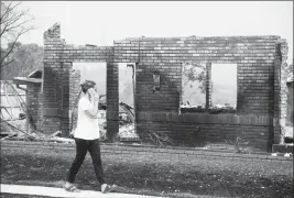  ?? ASSOCIATED PRESS ?? A WOMAN, WHO DECLINED TO GIVE HER NAME, surveys damage to her grandmothe­r’s house after the Carr Fire burned through Redding, Calif., on Friday. Officials say the extremely erratic wildfire in and around the city of Redding is growing rapidly amid...