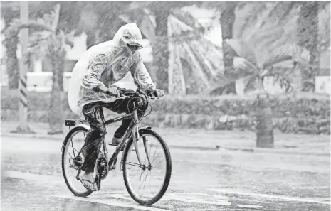  ?? RITCHIE B. TONGO, EUROPEAN PRESSPHOTO AGENCY ?? A man pushes through heavy rain as Typhoon Megi hits Taiwan on Tuesday. Megi’s heavy winds caused high waves on the coast.