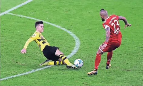  ?? FOTO: FIRO ?? Mittelfeld­strategen unter sich: Julian Weigl (Borussia Dortmund) grätscht gegen Bayern Münchens Arturo Vidal.