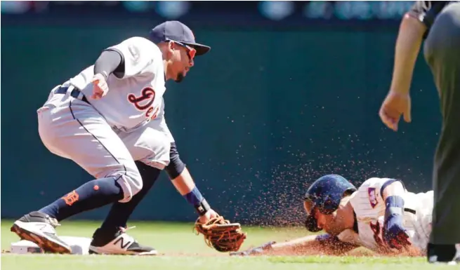  ?? — AP ?? MINNEAPOLI­S: Minnesota Twins’ Brian Dozier, right, slides into the waiting tag by Detroit Tigers shortstop Dixon Machado on a steal attempt in the first inning.