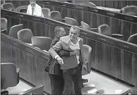  ?? AP/OLIVIER FITOUSSI ?? Jamal Zahalka, an Israeli Arab member of the Knesset, is removed from the chamber in Jerusalem as he protests Thursday’s passage of a bill declaring Israel the Jewish state.