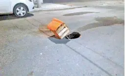  ??  ?? Una caja y un palo son los que alertan del socavón sobre el asfalto. /Víctor Cruz