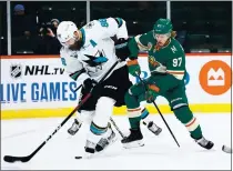  ?? HARRISON BARDEN – GETTY IMAGES ?? The Sharks’ Brent Burns, left, and Kirill Kaprizov of the Minnesota Wild battle for the puck during Friday night’s game in St Paul, Minn.