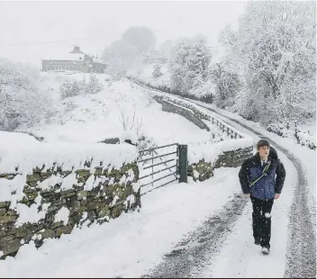  ??  ?? SCHOOLS CLOSED: A pupil from Ryburn Valley High School walks home in Cottonston­es. Bob Collier/PA