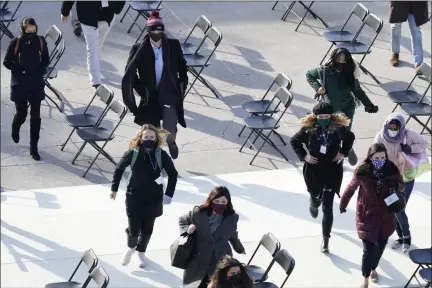  ?? CAROLYN KASTER — THE ASSOCIATED PRESS ?? People evacuate from the West Front of the U.S. Capitol during an inaugurati­on rehearsal on Monday.