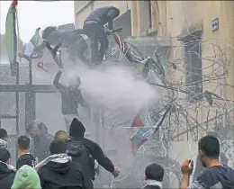  ?? Bilal Hussein/Associated Press ?? Protesters trying to enter the U.S. Embassy are sprayed by riot police using water cannons during a demonstrat­ion Sunday in Lebanon.