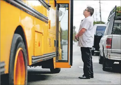  ?? Gary Coronado Los Angeles Times ?? PASCUAL waits for his son Jose to get off the school bus. Jose is a U.S. citizen, but Pascual lives in the country illegally.