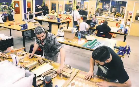  ?? Lake Fong/Post-Gazette ?? James Gyre, left, and David Villaverde of Naked Geometry make their wood products in June at TechShop in Bakery Square.