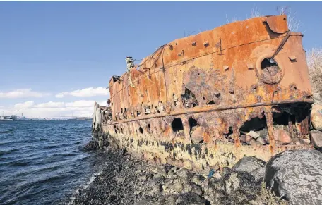  ?? ERIC WYNNE THE CHRONICLE HERALD ?? The SS Daisy embedded into the Dartmouth shoreline. The ship, originally built as a trawler for the British Navy, has been decaying near the Macdonald bridge for decades. •
