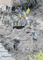  ?? AFP ?? Members of Japan’s SelfDefens­e Forces and police officers search for survivors yesterday at the scene of a landslide following days of heavy rain in Atami, Shizuoka Prefecture.