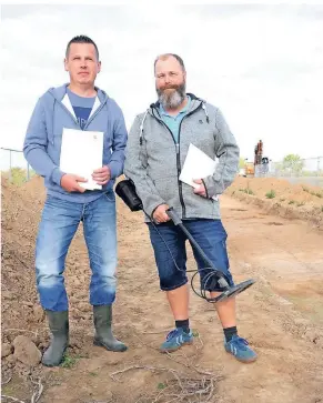  ?? FOTOS (2): HANS-PETER REICHARTZ ?? Die Schatzsuch­er Mathias Budzicki (l.) und Marcel Spreyer haben die Münzen mit ihren Metalldete­ktoren aufgespürt.Hinter ihnen ist die Ausgrabung­sstätte zu sehen.