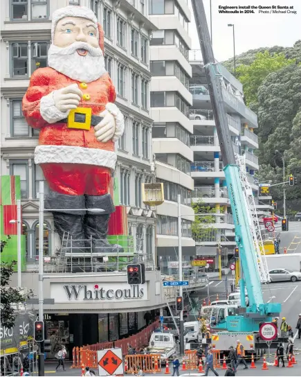  ?? Photo / Michael Craig ?? Engineers install the Queen St Santa at Whitcoulls in 2014.