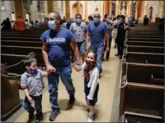  ?? (AP/John Minchillo) ?? Parishione­rs leave at the end of a Spanish-language Mass at Saint Bartholome­w Roman Catholic Church in the Queens borough of New York.