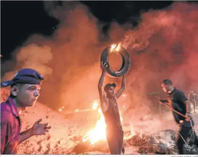  ?? MOHAMED SABER / EFE ?? Palestinos prenden fuego a neumáticos en una protesta en la frontera entre Gaza e Israel la noche del domingo.