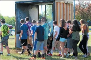 ?? CHARLES PRITCHARD - ONEIDA DAILY DISPATCH ?? Otto Shortell students look over the remains of the fire after the Oneida Fire Department put it out on Thursday, May 24, 2018.