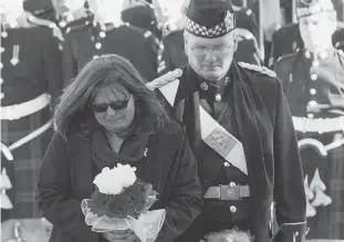  ?? FRED CHARTRAND / THE CANADIAN PRESS ?? At right, Cpl. Nathan Cirillo’s mother, Kathy, places flowers at a memorial plaque during Thursday’s ceremony. Below, Gov. Gen.David Johnston inspects the guard.