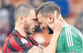  ??  ?? AC Milan’s Leonardo Bonucci, left, consoles keeper Gianluigi Donnarumma.