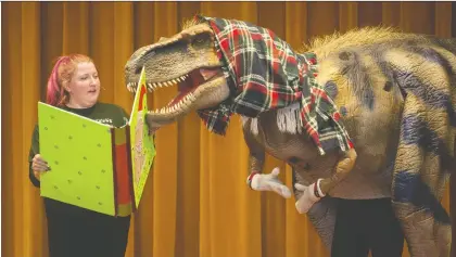  ?? BRANDON HARDER ?? Hannah Dove, gallery interprete­r for the Royal Saskatchew­an Museum, reads to a person wearing a dinosaur costume as part of the ’Twas the Night Before Hibernatio­n play in the Museum’s auditorium in its main building on Albert Street on Saturday.