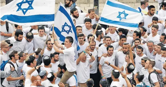  ?? ARIEL SCHALIT/AP ?? Festa. Jovens israelense­s comemoram, na Cidade Velha de Jerusalém, a aprovação da lei que define o país como um ‘Estado-nação judeu’