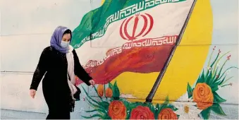  ?? AFP ?? Il grande giorno. Un’iraniana passa davanti a un murales nelle strade di Teheran. Oggi si vota per il nuovo presidente