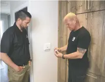  ?? THE HOLMES GROUP ?? Contractor and TV host Mike Holmes, right, discusses Swidget smart switches options with Chris Adamson on an episode of Holmes Family Rescue. Safety is key with all smart options, Holmes says.