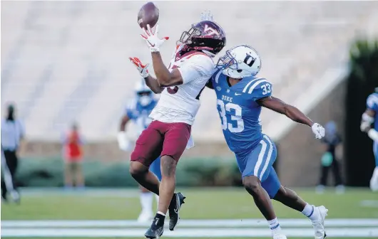  ?? NELL REDMOND PHOTOS/ASSOCIATED PRESS ?? Virginia Tech wide receiver Tayvion Robinson, a former Cox High star, tries to pull in a reception as he is defended by Duke cornerback Leonard Johnson on Saturday.