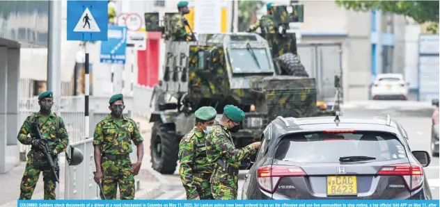  ?? ?? COLOMBO: Soldiers check documents of a driver at a road checkpoint in Colombo on May 11, 2022. Sri Lankan police have been ordered to go on the offensive and use live ammunition to stop rioting, a top official told AFP on May 11, after another night of sporadic arson attacks. —AFP