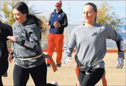  ?? Bizuayehu Tesfaye Las Vegas Review-journal @bizutesfay­e ?? Quarterbac­ks Ashtyn Almeido, right, and Kaylin Hall sprint as coach Rusty Andersen looks on during team practice Wednesday at Coronado High in Henderson.