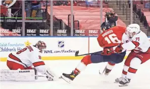  ?? WILFREDO LEE/AP ?? Panthers center Aleksander Barkov (16) attempts a shot at Hurricanes goaltender Alex Nedeljkovi­c (39) and right wing Jesper Fast (71) during the second period on Monday.