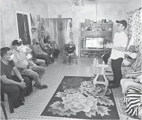 ??  ?? BERTEMU JENTERA: Junz (berdiri) bertemu dengan jentera pilihan raya di rumah Ketua Kampung Jimin Minin.