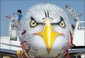  ?? AP/MICHEL EULER ?? A man looks out the door of an Embraer E195-E2 prototype Sunday on the eve of the Paris Air Show’s opening in Le Bourget, France.