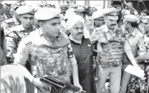  ?? ?? Police officers escort Atiq Ahmed, a former lawmaker in India’s parliament, accused in several criminal cases, outside a court in Prayagraj, India, April 13, 2023. (Reuters photo)