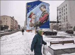  ?? YURI KADOBNOV/AFP VIA GETTY IMAGES ?? A pedestrian walks past a mural depicting a Russian General and a cadet with a slogan reading “There is such a profession — to defend the homeland” in Moscow on Tuesday.