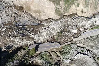  ?? DAVID GOLDMAN / AP ?? Receding floodwater­s flow past sections of North Entrance Road washed away at Yellowston­e National Park in Gardiner, Mont., on June 16.