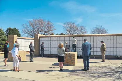  ?? Hyoung Chang, The Denver Post ?? Susie Sigman of Denver, front center, held an interment service May 1 for her mother, Barbara Mannis, at Fort Logan National Cemetery in Denver. Video of the service was streamed to the family via Zoom.