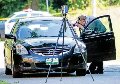  ?? [THE OKLAHOMAN ARCHIVES] ?? An investigat­or photograph­s the inside of a car on June 20, 2016, at the scene of a double homicide near NE 15th and Highland in Oklahoma City.