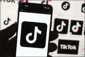  ?? MICHAEL DWYER — THE ASSOCIATED PRESS FILE ?? The TikTok logo is seen on a phone in front of a computer screen which displays the TikTok home screen on Oct. 14, 2022, in Boston.